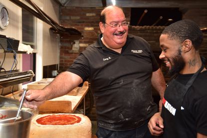 Gary Bimonte and boxer Tramaine Williams at a food event for schoolchildren set up by Taste of New Haven. Bimonte, of the Frank Pepes pizza dynasty, died this week. (Courtesy of Colin Caplan and the Hartford Courant.)